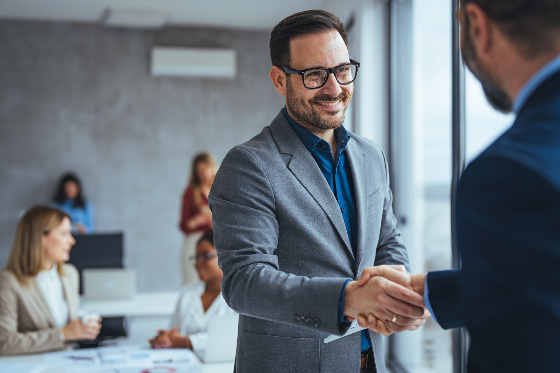 Portrait of cheerful young manager handshake with new employee.